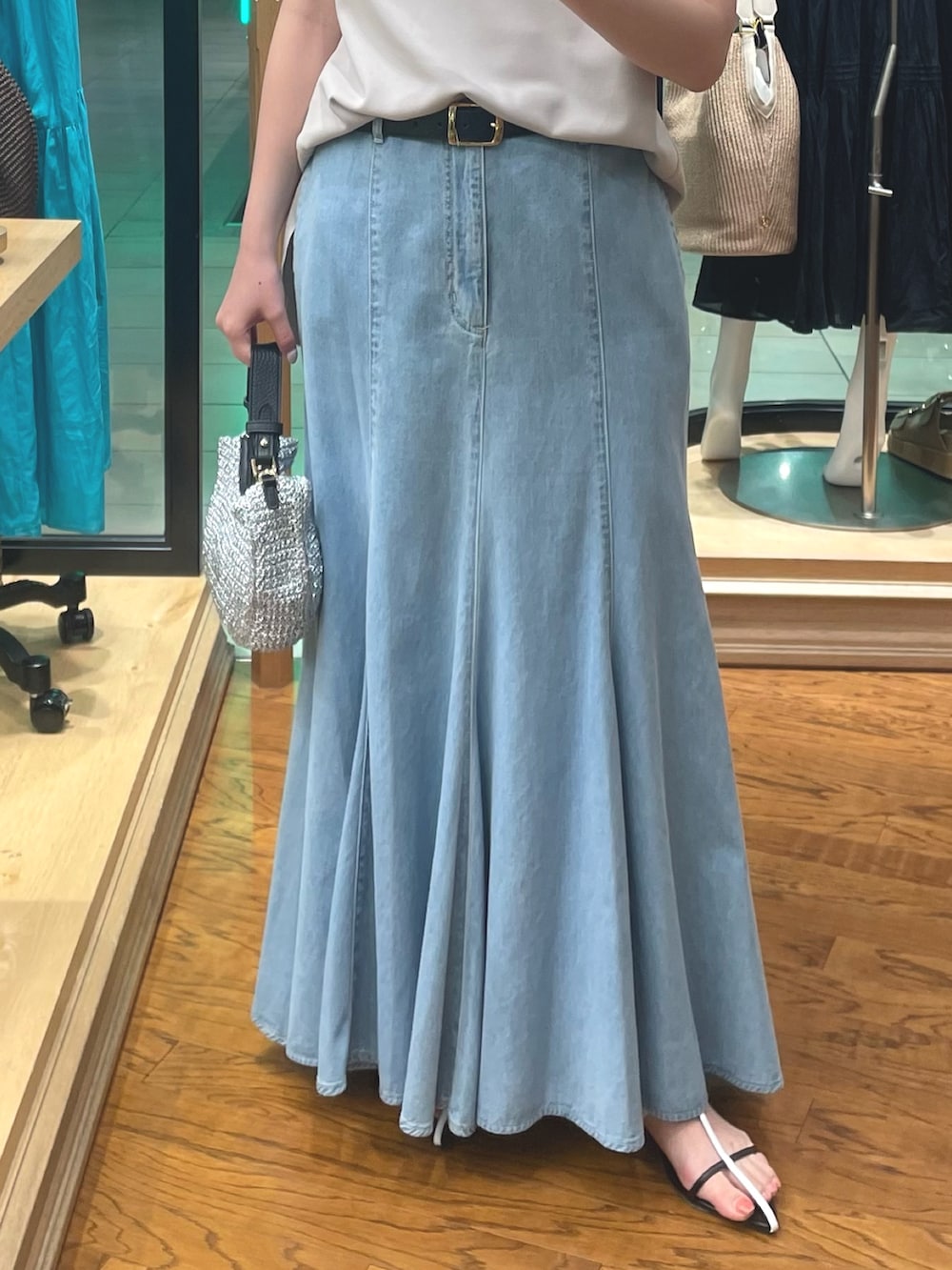 ブルー系のスカート、ベージュ系のTシャツ/カットソー、ブラック系のサンダルを着用したレディースの夏コーディネートの3枚目の写真