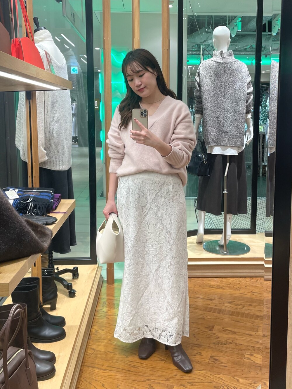 ピンク系のニット/セーター、ホワイト系のスカート、ホワイト系のハンドバッグを着用したレディースの秋コーディネートの4枚目の写真