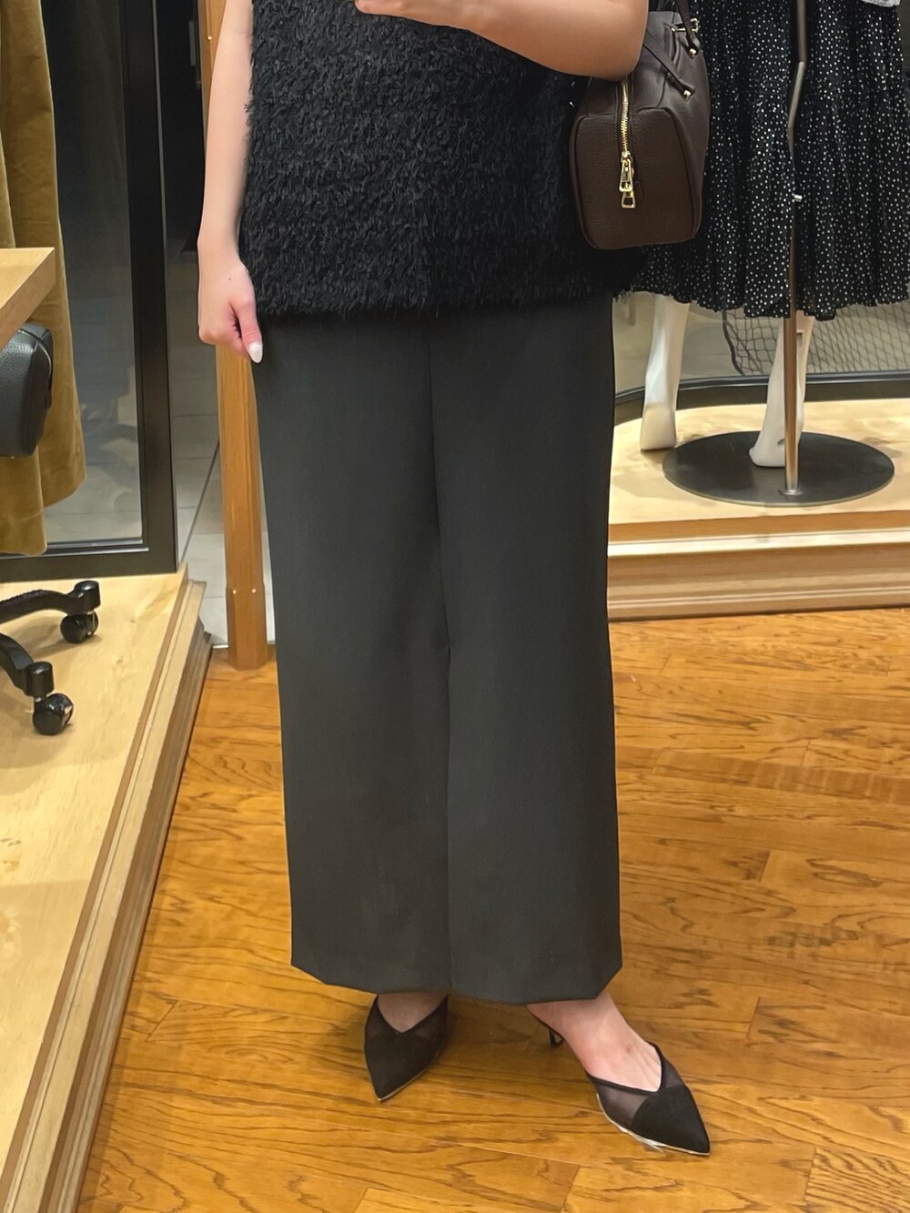 ブラウン系のショルダーバッグ、グレー系のスカート、ブラック系のベストを着用したレディースの夏コーディネートの3枚目の写真