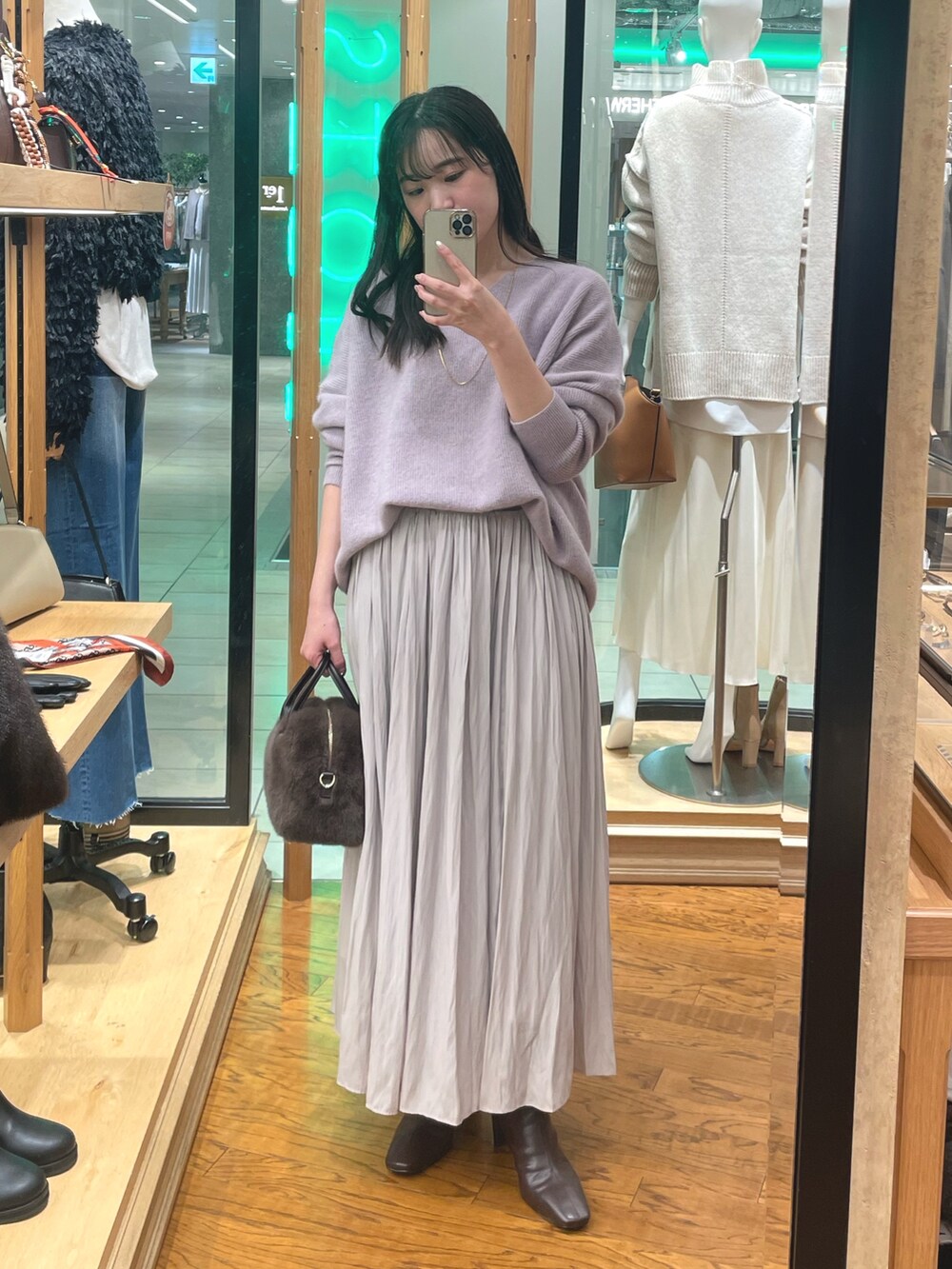 パープル系のニット/セーター、ブラウン系のボストンバッグ、ブラウン系のブーツを着用したレディースの冬コーディネートの4枚目の写真