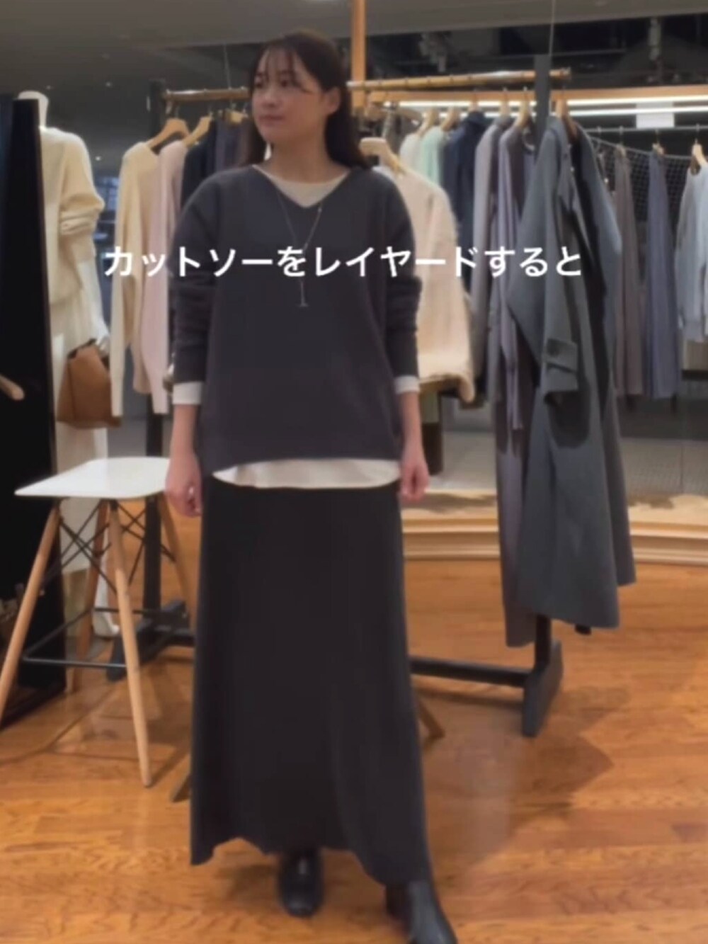 グレー系のニット/セーター、ホワイト系のスラックスを着用したレディースの冬コーディネートの2枚目の写真