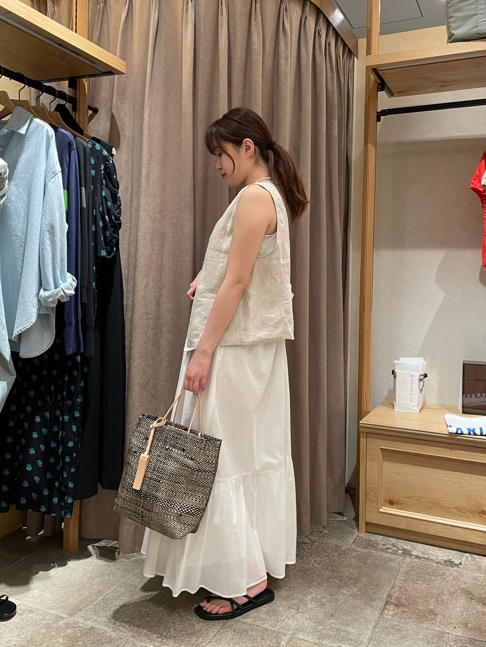 ベージュ系のその他アウター、ホワイト系のワンピース、ブラック系のサンダルを着用したレディースの夏コーディネートの2枚目の写真