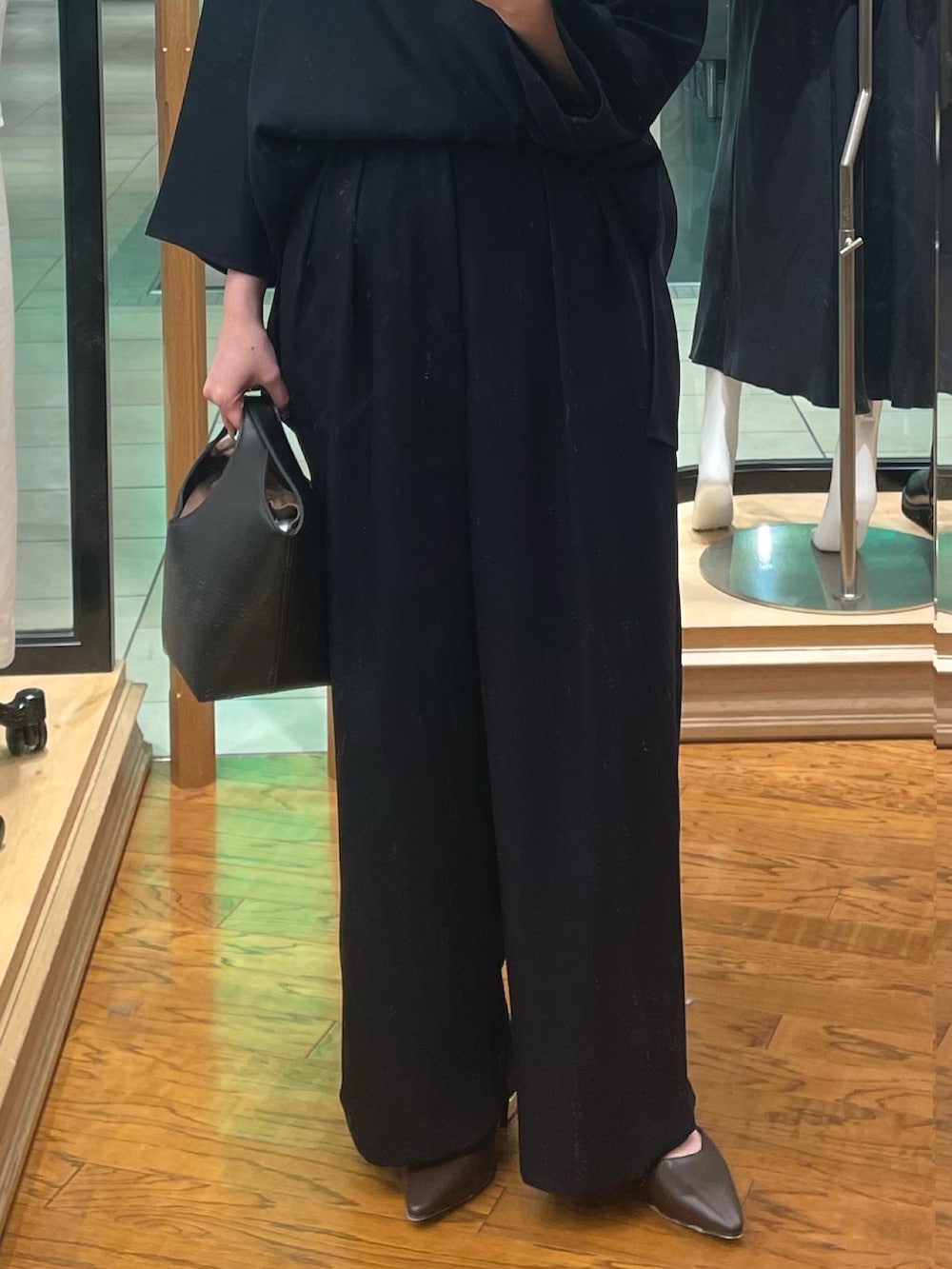 ブルー系のシャツ/ブラウス、ブルー系のスラックス、ブラック系のハンドバッグを着用したレディースの冬コーディネートの3枚目の写真