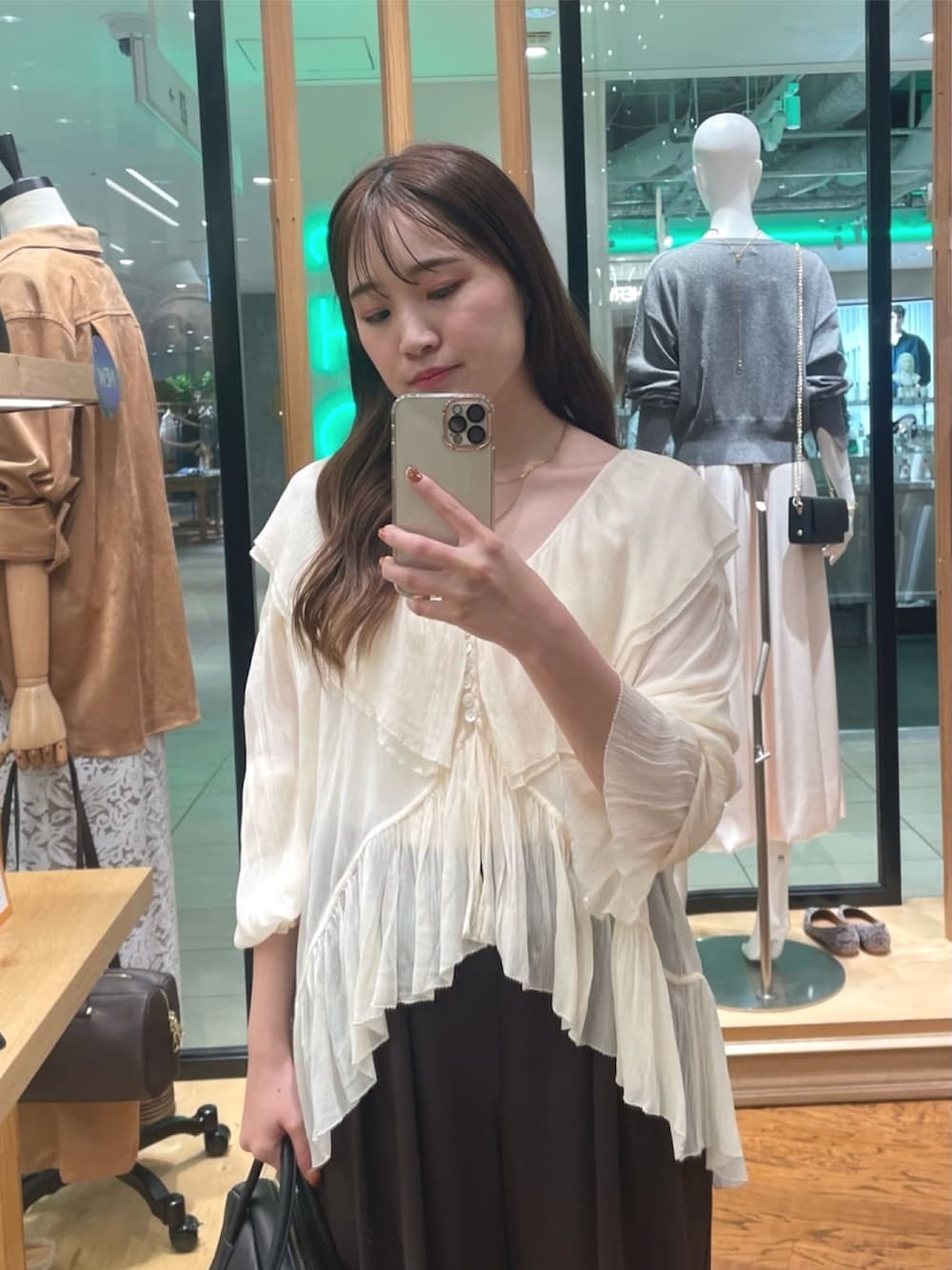 ブラウン系のスラックス、ブラック系のボストンバッグ、ブラック系のパンプスを着用したレディースの秋コーディネートの2枚目の写真