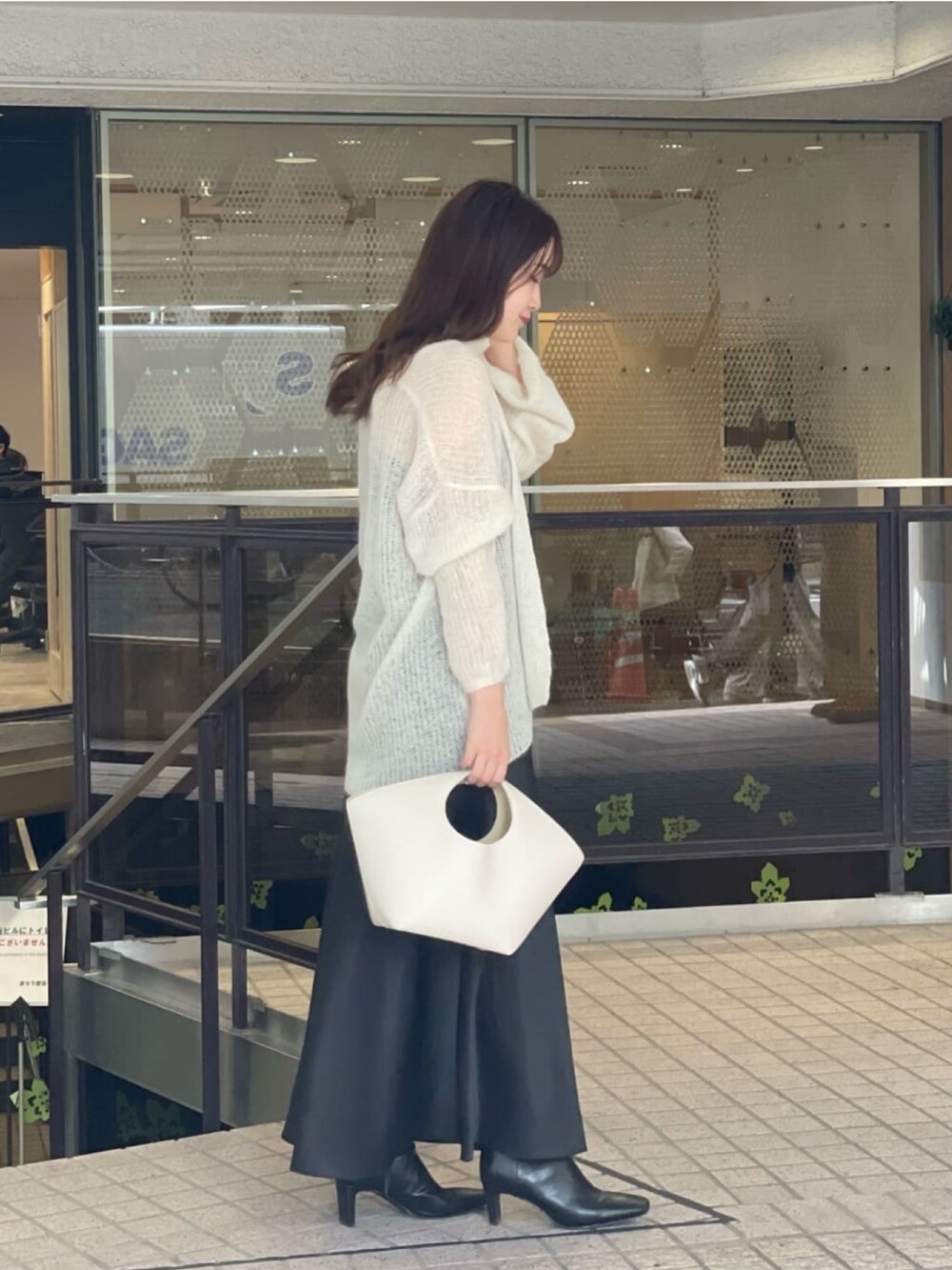 ホワイト系のニット/セーター、ブラック系のスカート、ブラック系のブーツを着用したレディースの秋コーディネートの3枚目の写真