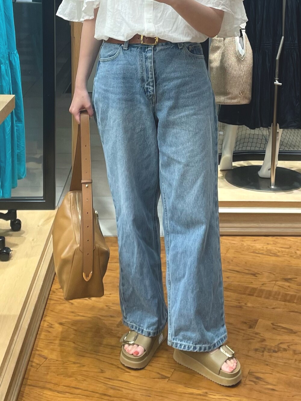 ブラウン系のボディバッグ/ウエストポーチ、ホワイト系のシャツ/ブラウス、ベージュ系のサンダルを着用したレディースの夏コーディネートの3枚目の写真