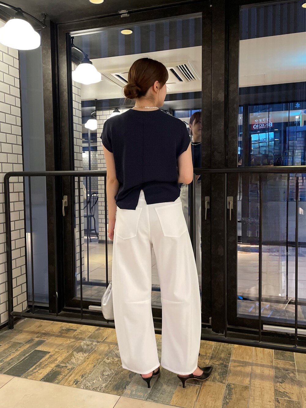 ブルー系のニット/セーター、ホワイト系のその他パンツ、シルバー系のショルダーバッグを着用したレディースの夏コーディネートの3枚目の写真