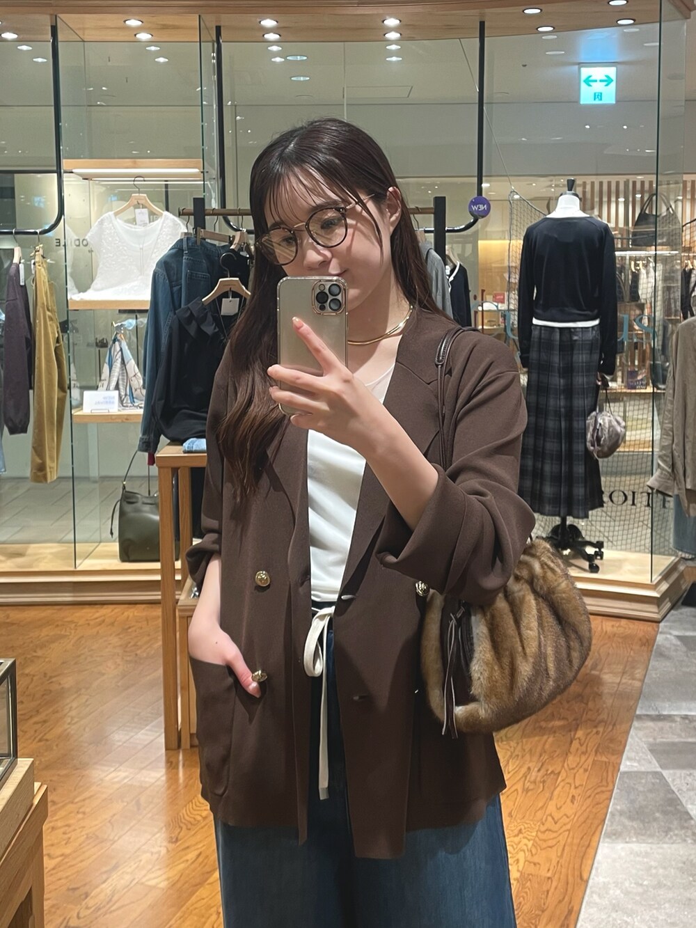 イエロー系のハンドバッグ、ブルー系のデニムパンツ、ベージュ系のパンプスを着用したレディースの夏コーディネートの2枚目の写真