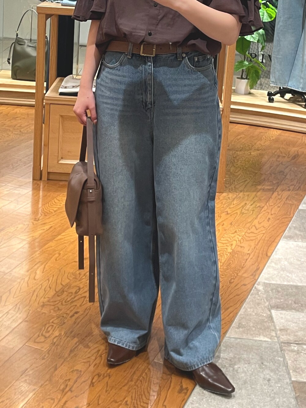 ブラウン系のシャツ/ブラウス、ブルー系のデニムパンツ、ブラウン系のショルダーバッグを着用したレディースの夏コーディネートの3枚目の写真