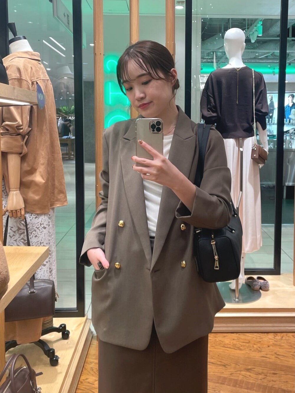 ブラウン系のテーラードジャケット、ブラウン系のスカート、ホワイト系のTシャツ/カットソーを着用したレディースの秋コーディネートの2枚目の写真