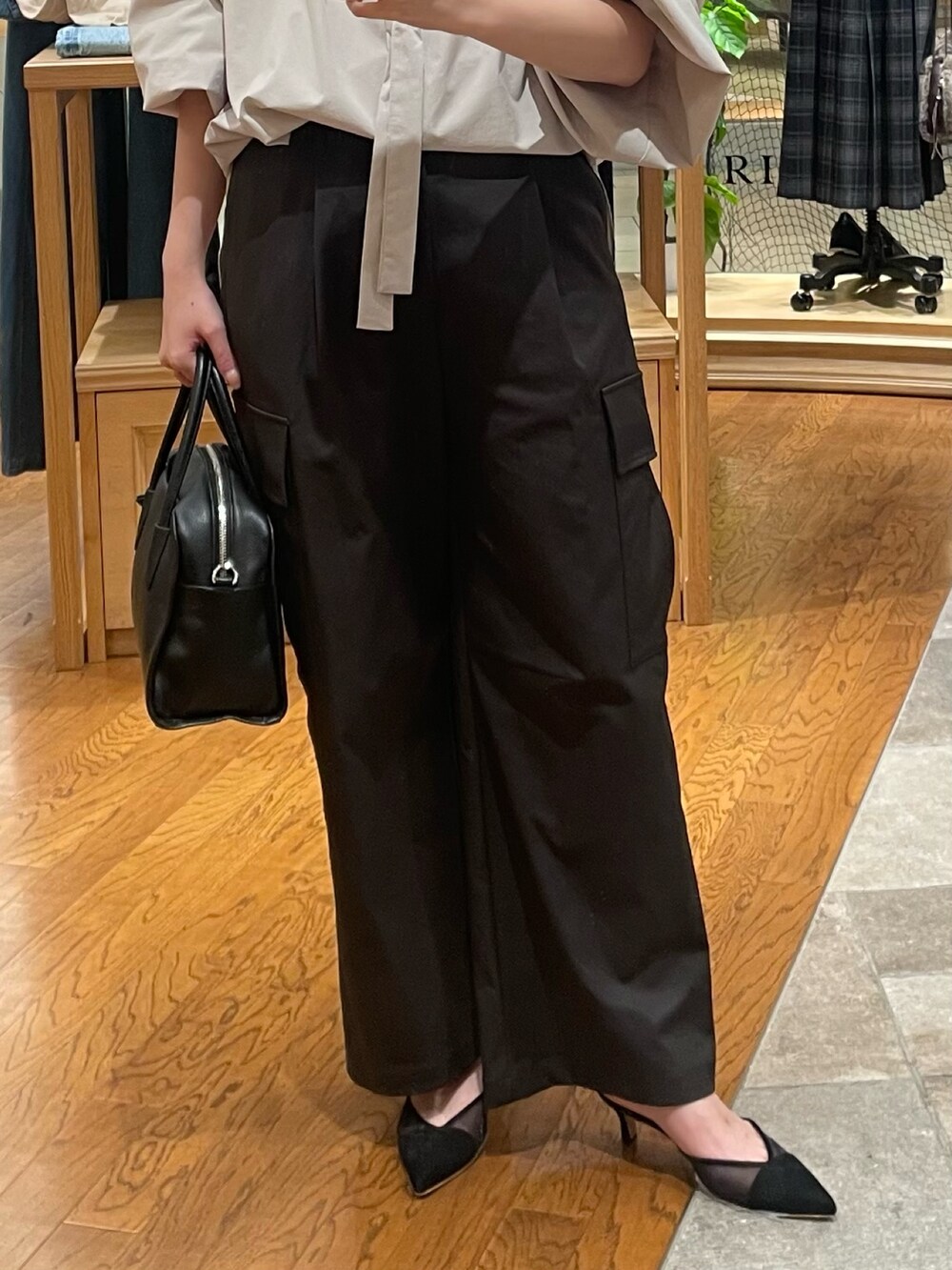 ブラウン系のカーゴパンツ、ブラック系のパンプス、ブラック系のボストンバッグを着用したレディースの夏コーディネートの3枚目の写真