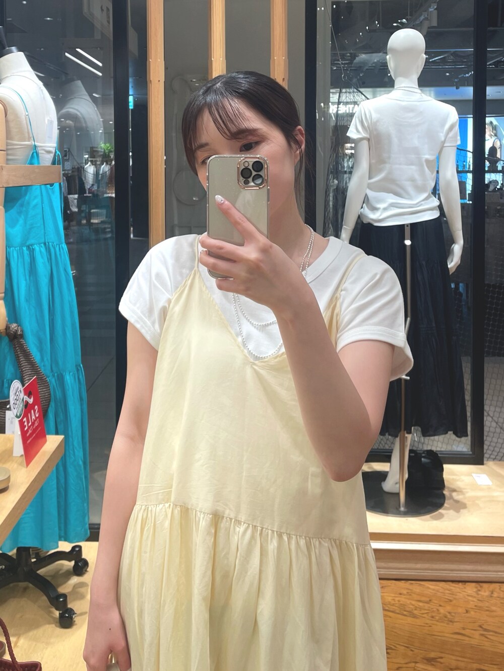 ホワイト系のワンピース、ホワイト系のTシャツ/カットソー、シルバー系のサンダルを着用したレディースの夏コーディネートの2枚目の写真