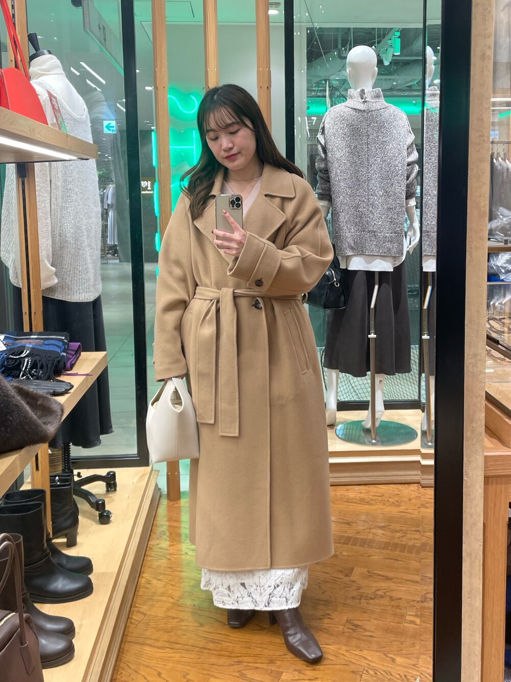 イエロー系のその他アウター、ホワイト系のハンドバッグ、ブラウン系のブーツを着用したレディースの秋コーディネートの3枚目の写真