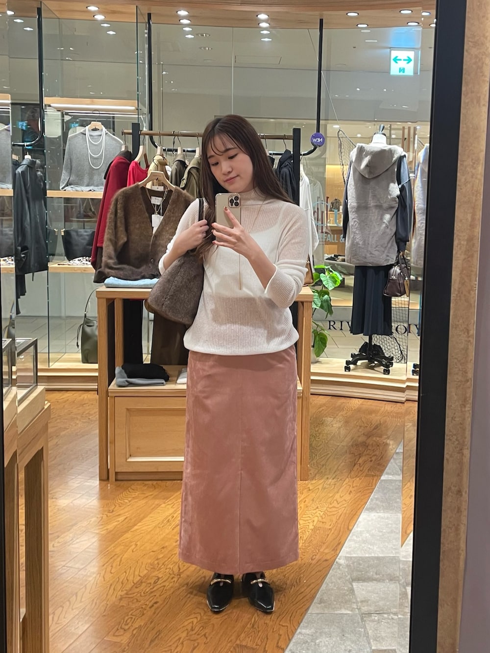 ピンク系のスカート、ブラック系のその他シューズ、ホワイト系のニット/セーターを着用したレディースの秋コーディネートの4枚目の写真