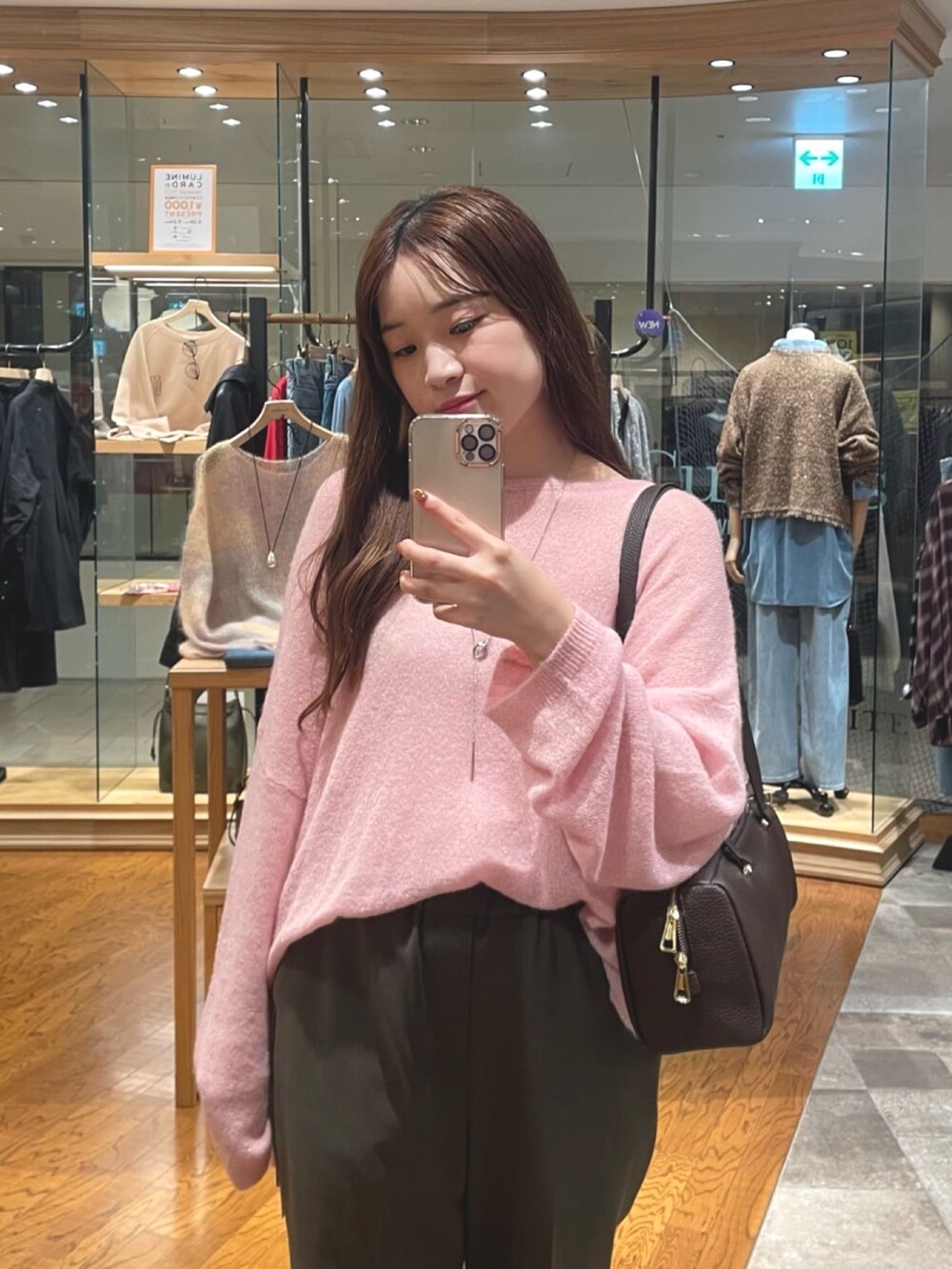 ピンク系のニット/セーター、ブラック系のショルダーバッグ、ブラウン系のその他パンツを着用したレディースの秋コーディネートの2枚目の写真