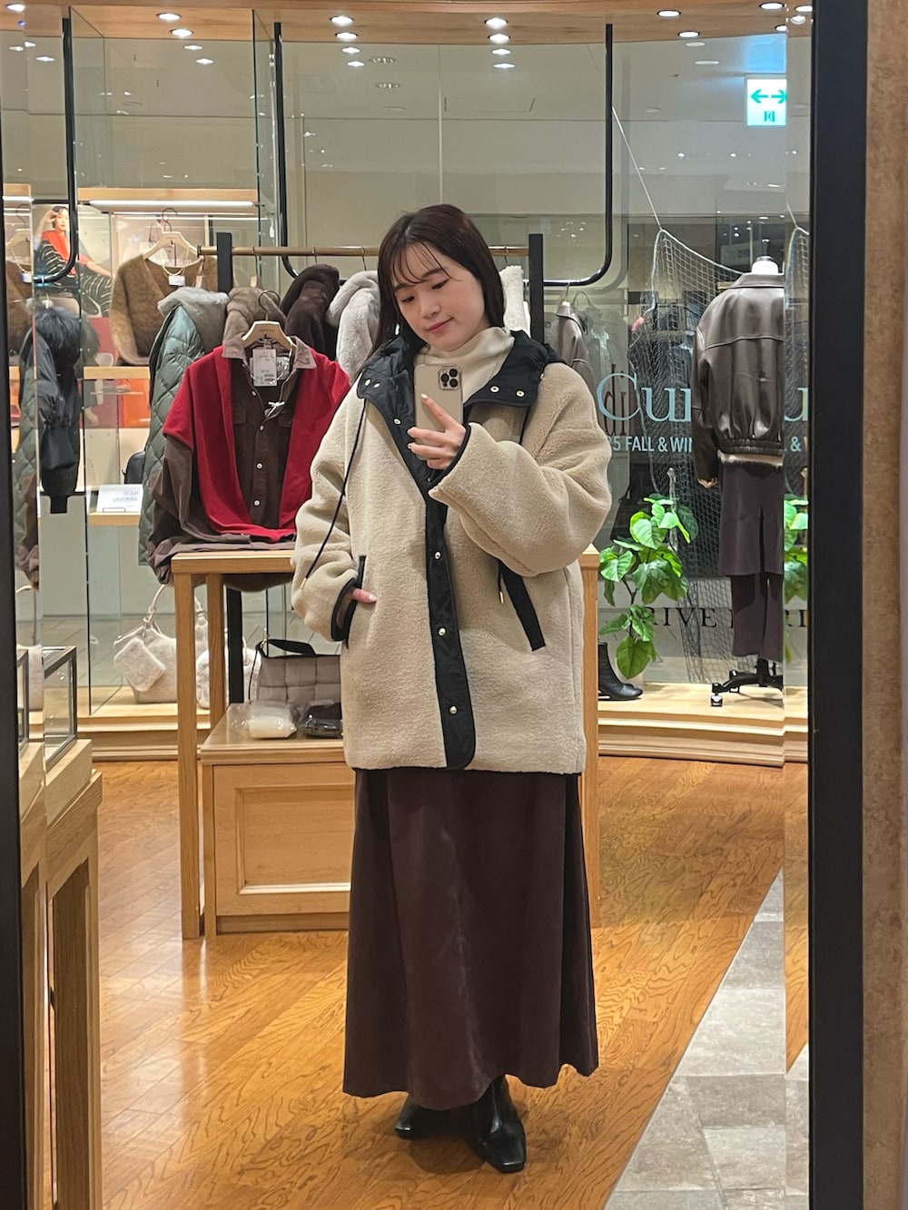 ベージュ系のその他アウター、ブラウン系のスカート、ブラック系のブーツを着用したレディースの秋コーディネートの3枚目の写真