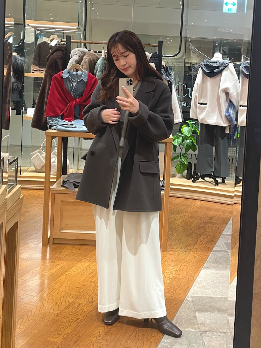 グレー系のその他アウター、ホワイト系のスラックス、ブラウン系のブーツを着用したレディースの秋コーディネートの3枚目の写真