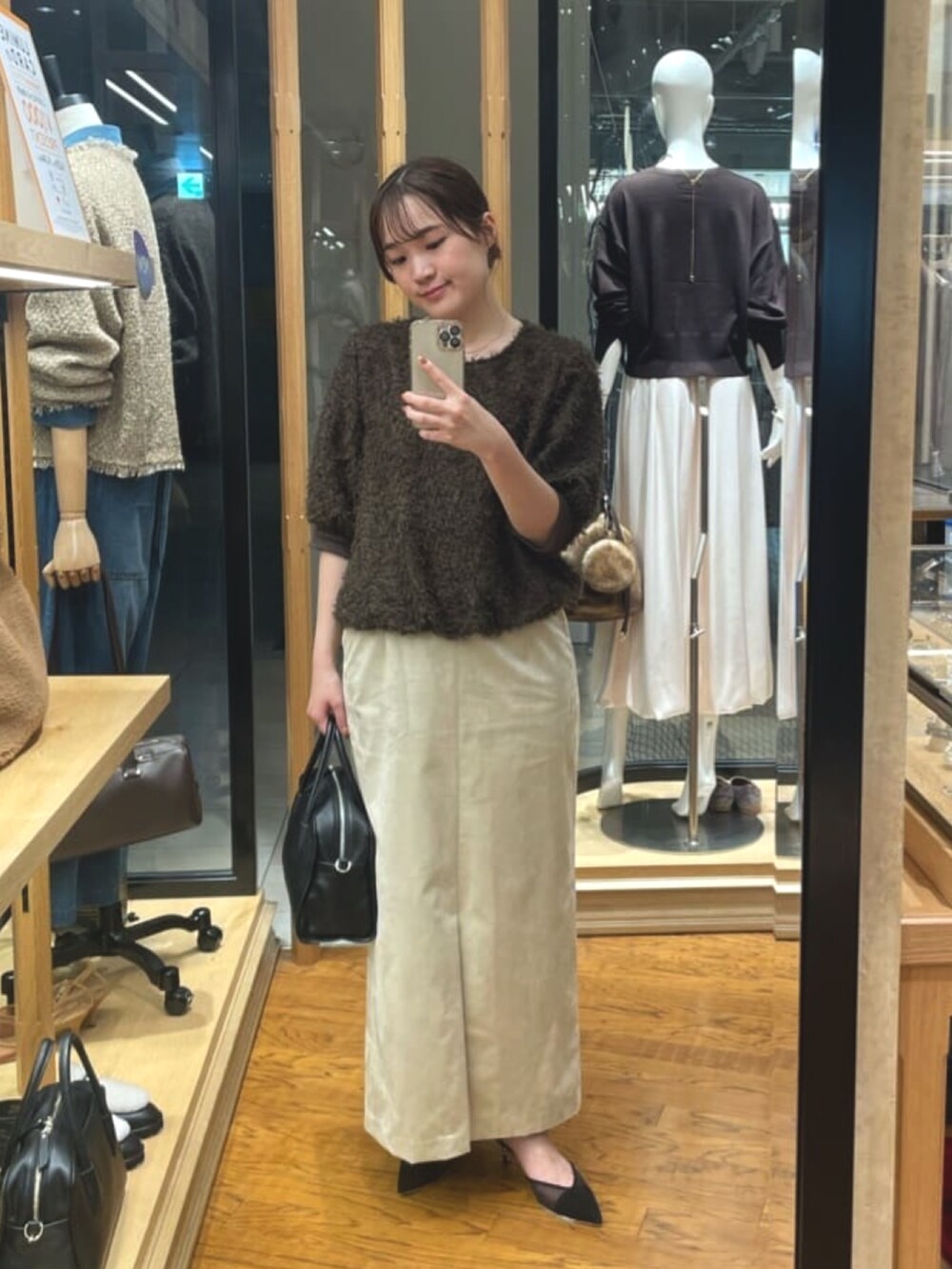 ベージュ系のスカート、ブラック系のボストンバッグ、ブラウン系のシャツ/ブラウスを着用したレディースの秋コーディネートの4枚目の写真