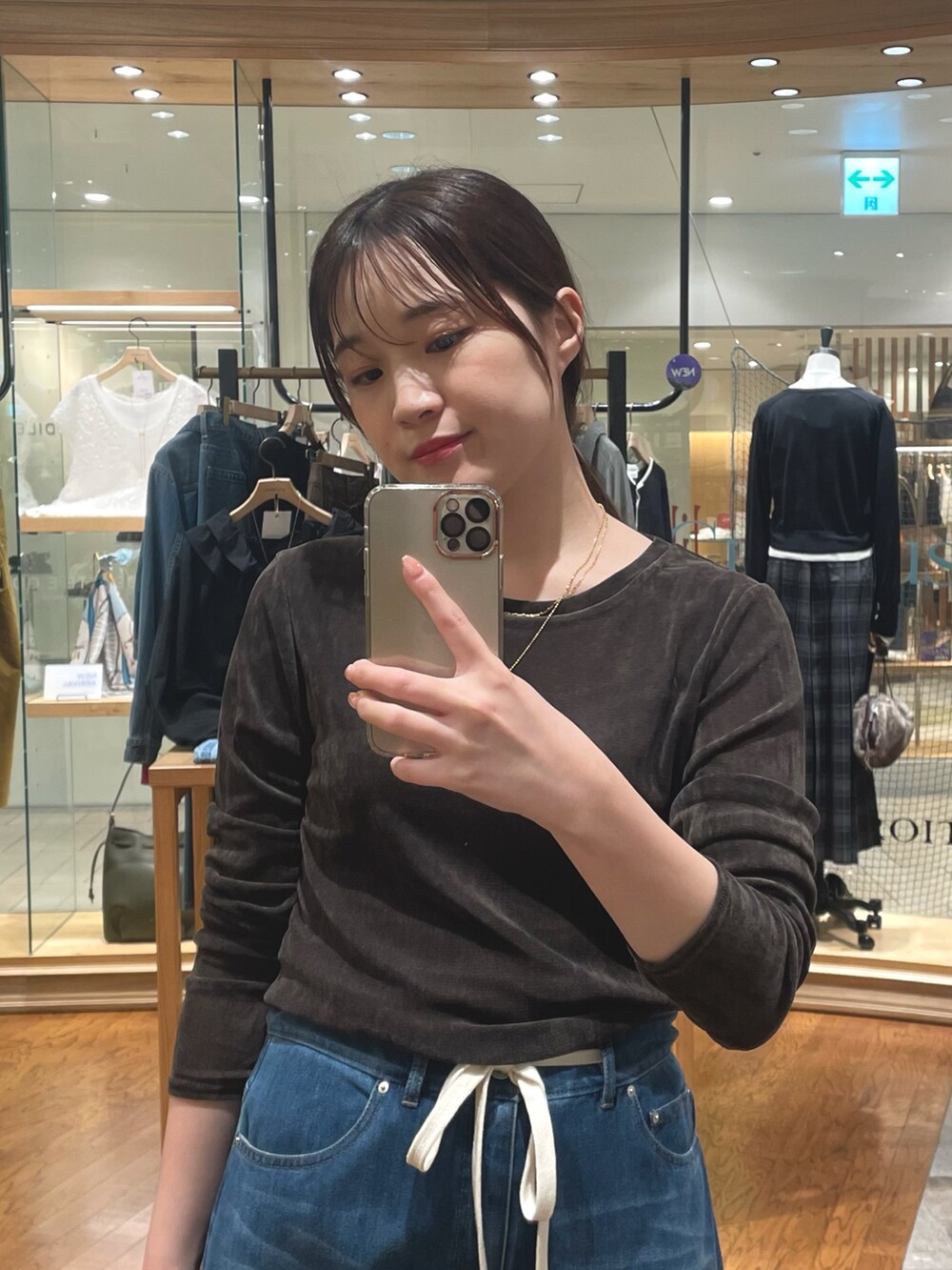 ブルー系のデニムパンツ、ベージュ系のパンプス、イエロー系のボストンバッグを着用したレディースの夏コーディネートの2枚目の写真