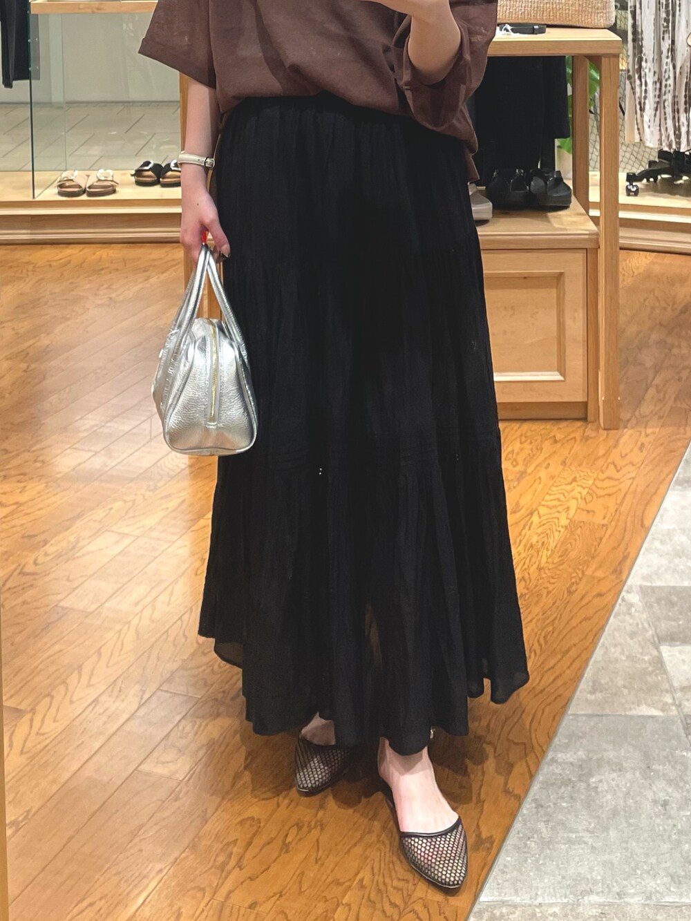 ブラック系のスカート、ブラック系のパンプス、ブラウン系のニット/セーターを着用したレディースの夏コーディネートの3枚目の写真