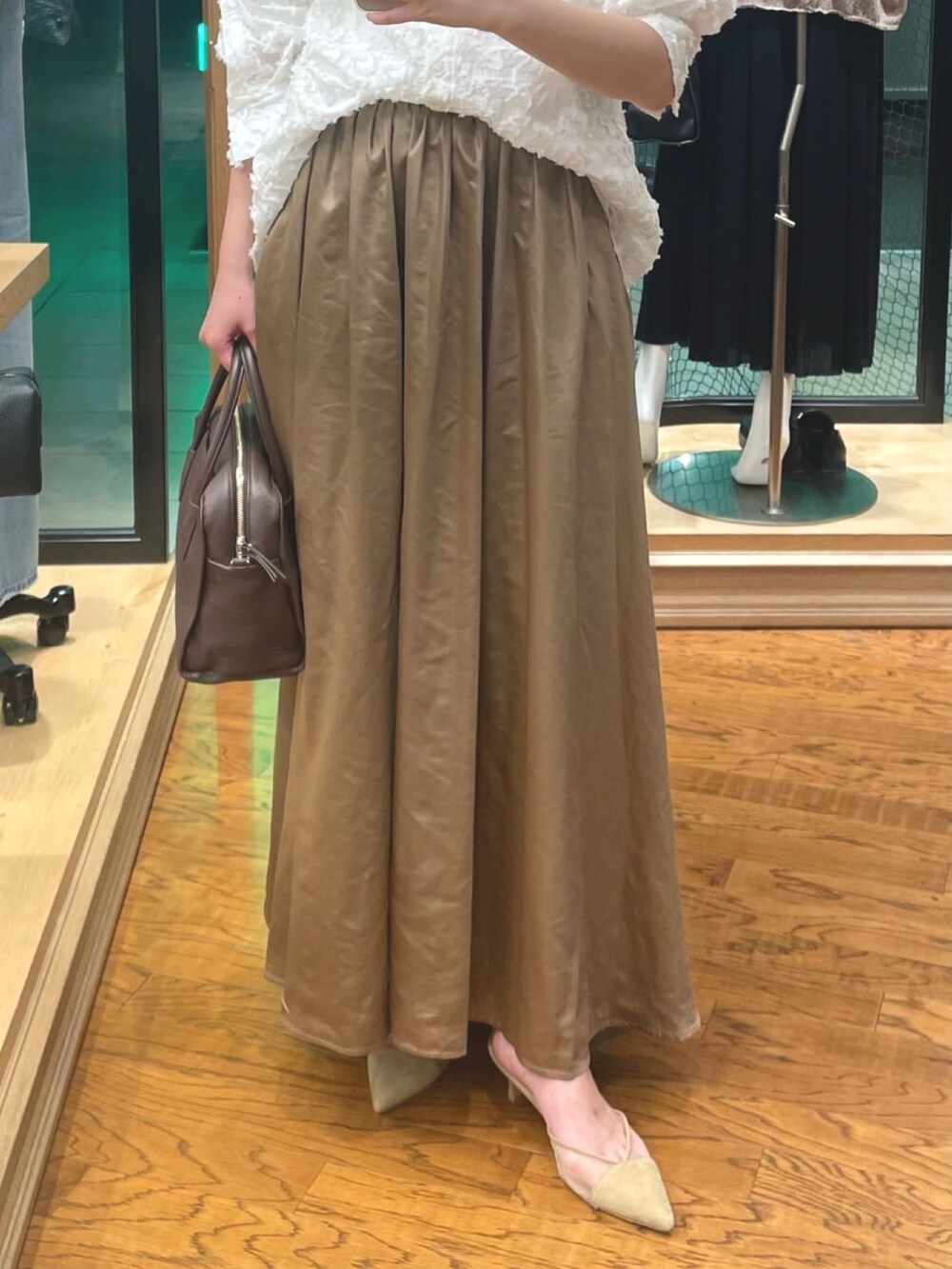 ホワイト系のシャツ/ブラウス、ブラウン系のスカート、ベージュ系のパンプスを着用したレディースの夏コーディネートの3枚目の写真