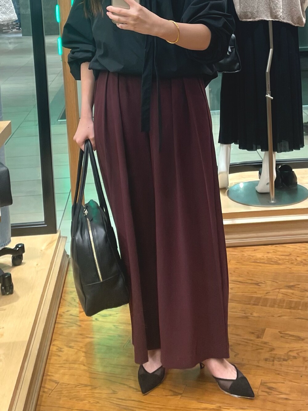 ブラック系のシャツ/ブラウス、レッド系のスラックス、ブラック系のボストンバッグを着用したレディースの夏コーディネートの3枚目の写真