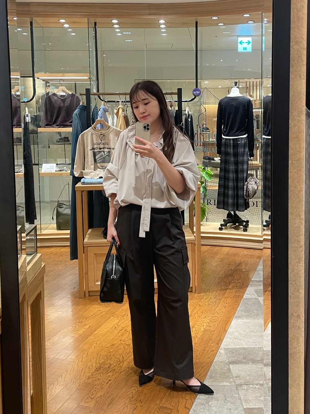 ブラウン系のカーゴパンツ、ブラック系のパンプス、ブラック系のボストンバッグを着用したレディースの夏コーディネートの4枚目の写真