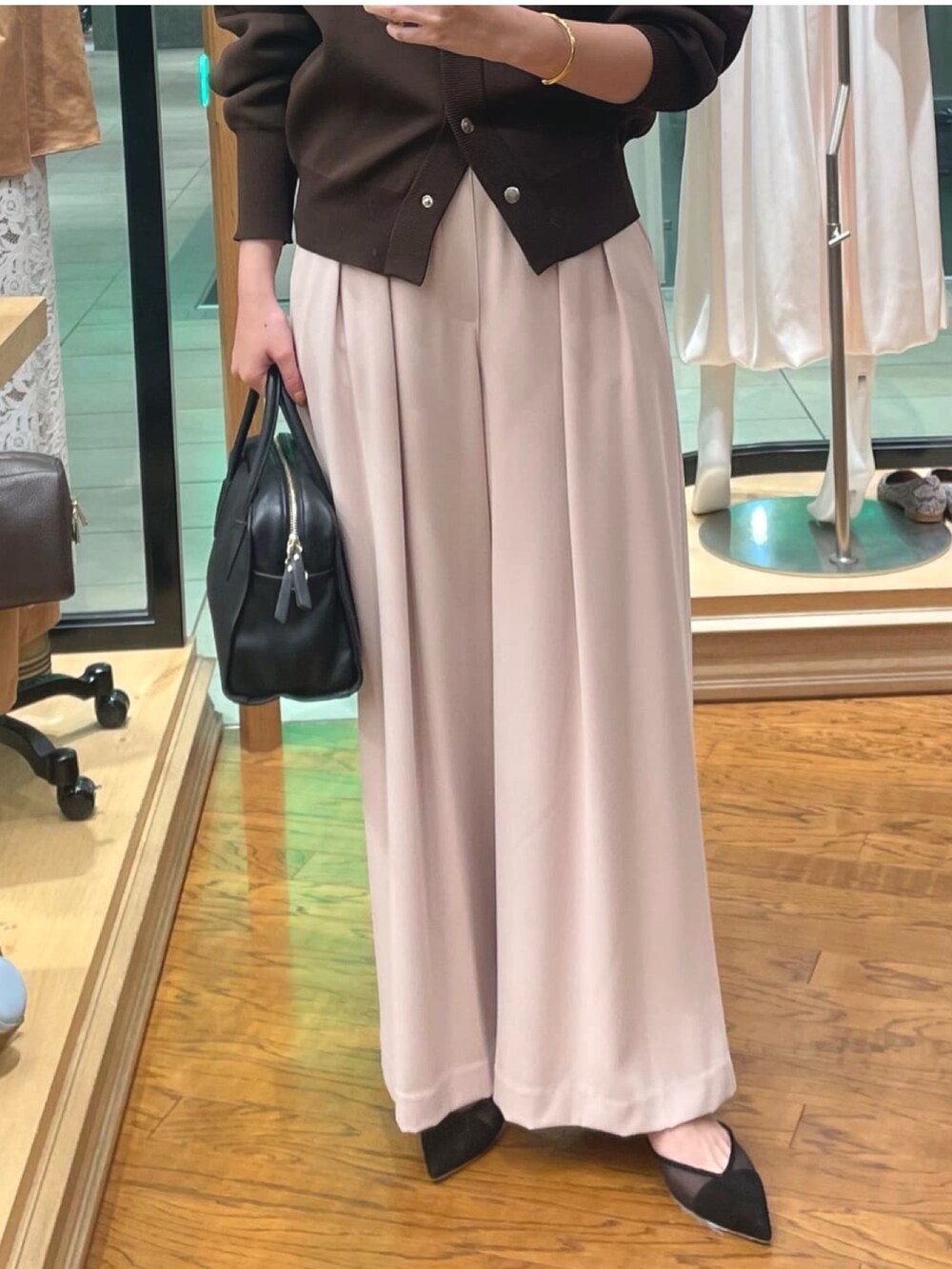 ピンク系のスラックス、ブラック系のボストンバッグ、ブラック系のパンプスを着用したレディースの秋コーディネートの3枚目の写真