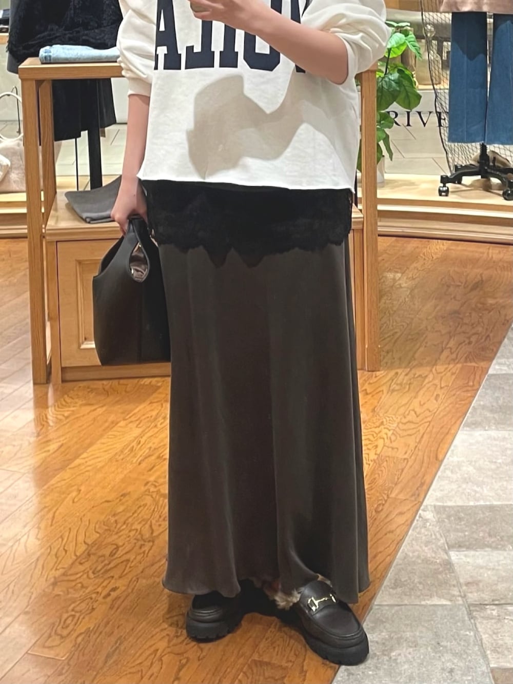 ホワイト系のスウェット、ブラウン系のキャミソール、ブラウン系のスカートを着用したレディースの冬コーディネートの3枚目の写真