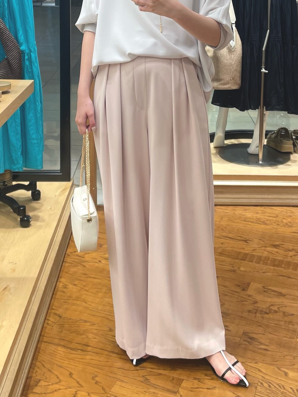 グレー系のシャツ/ブラウス、ピンク系のスラックス、ホワイト系のショルダーバッグを着用したレディースの夏コーディネートの3枚目の写真