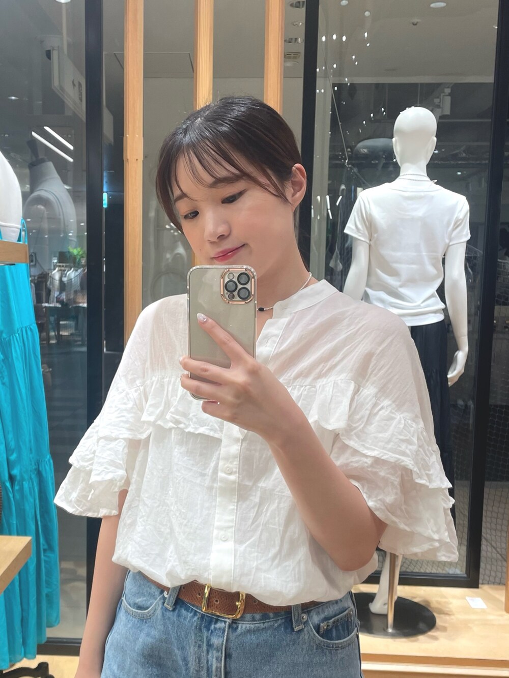 ブラウン系のボディバッグ/ウエストポーチ、ホワイト系のシャツ/ブラウス、ベージュ系のサンダルを着用したレディースの夏コーディネートの2枚目の写真