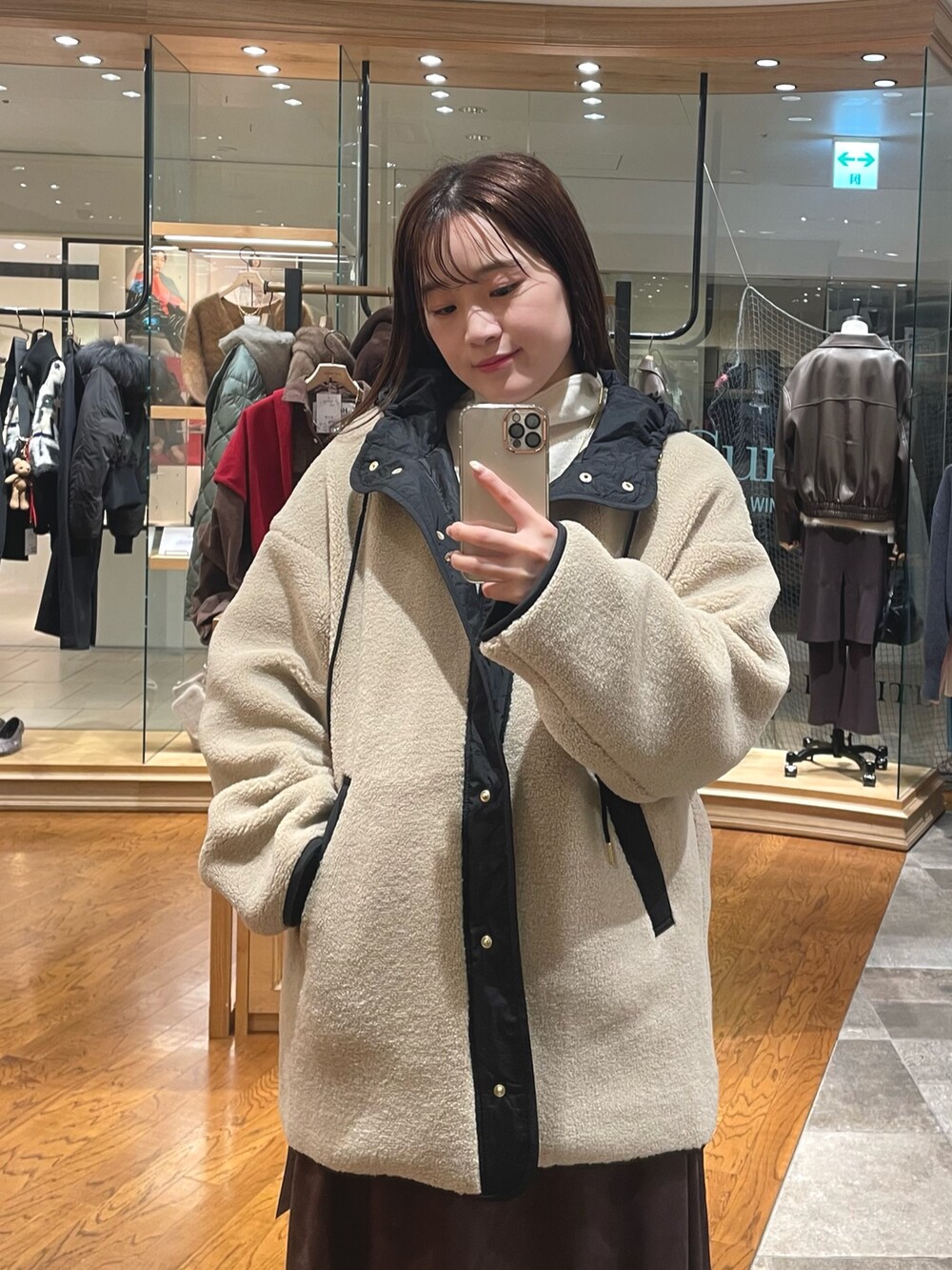 ベージュ系のその他アウター、ブラウン系のスカート、ブラック系のブーツを着用したレディースの秋コーディネートの2枚目の写真