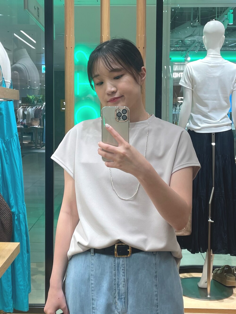 ブルー系のスカート、ベージュ系のTシャツ/カットソー、ブラック系のサンダルを着用したレディースの夏コーディネートの2枚目の写真