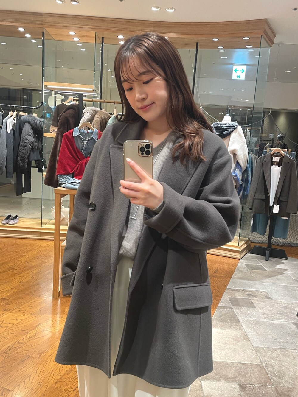 グレー系のその他アウター、ホワイト系のスラックス、ブラウン系のブーツを着用したレディースの秋コーディネートの2枚目の写真