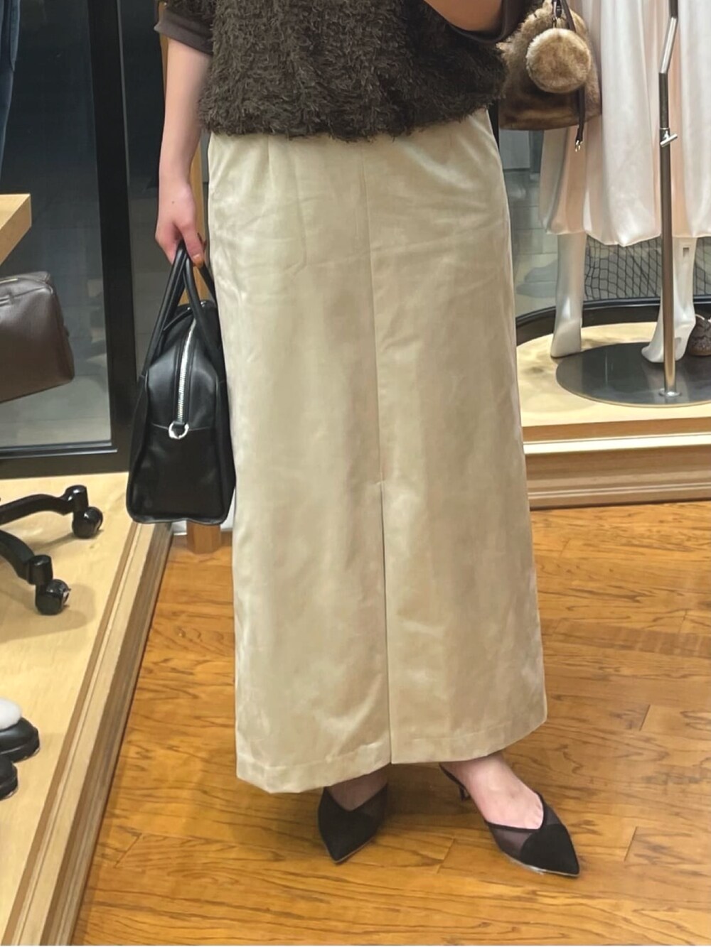 ベージュ系のスカート、ブラック系のボストンバッグ、ブラウン系のシャツ/ブラウスを着用したレディースの秋コーディネートの3枚目の写真