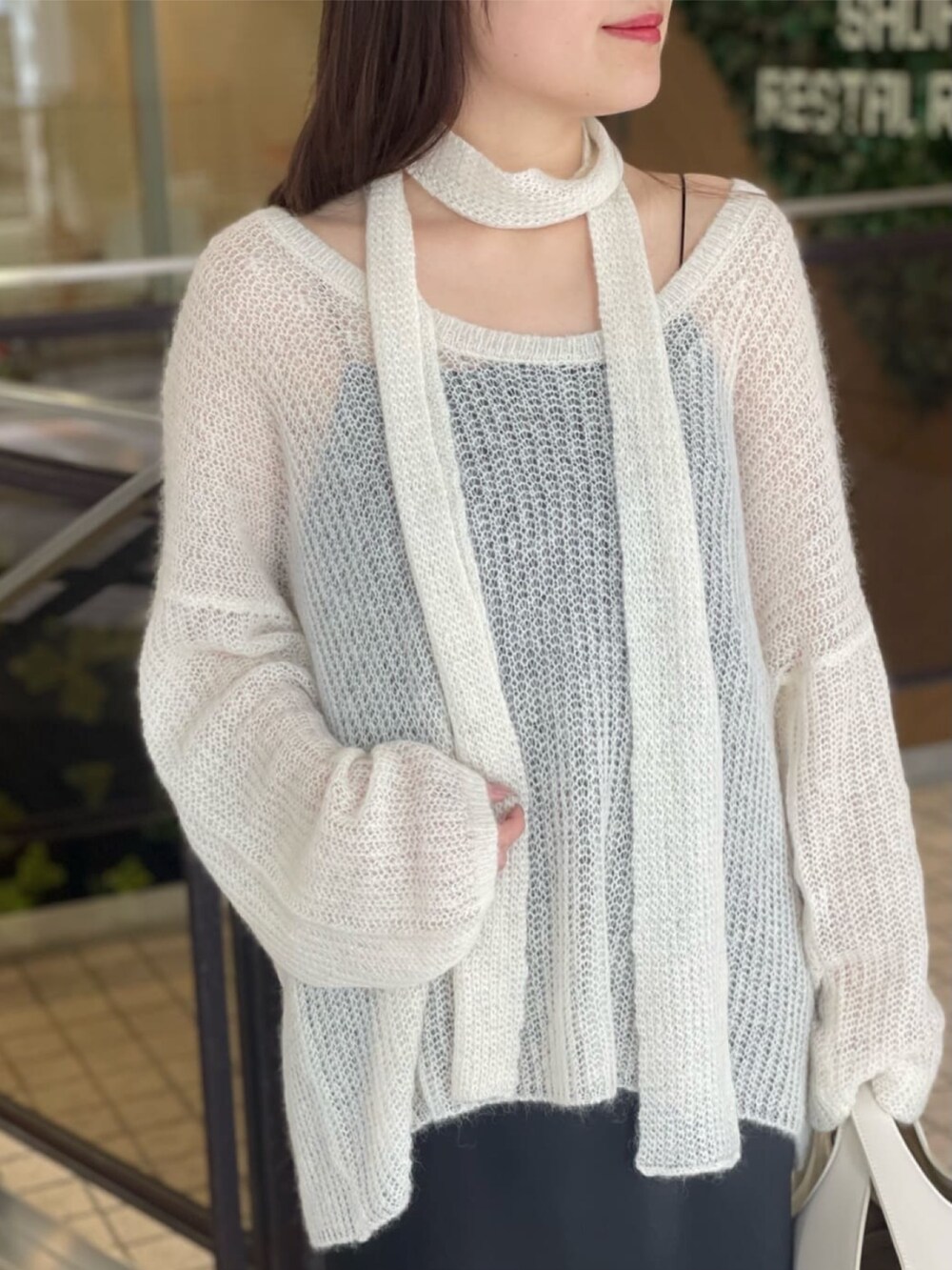 ホワイト系のニット/セーター、ブラック系のスカート、ブラック系のブーツを着用したレディースの秋コーディネートの2枚目の写真