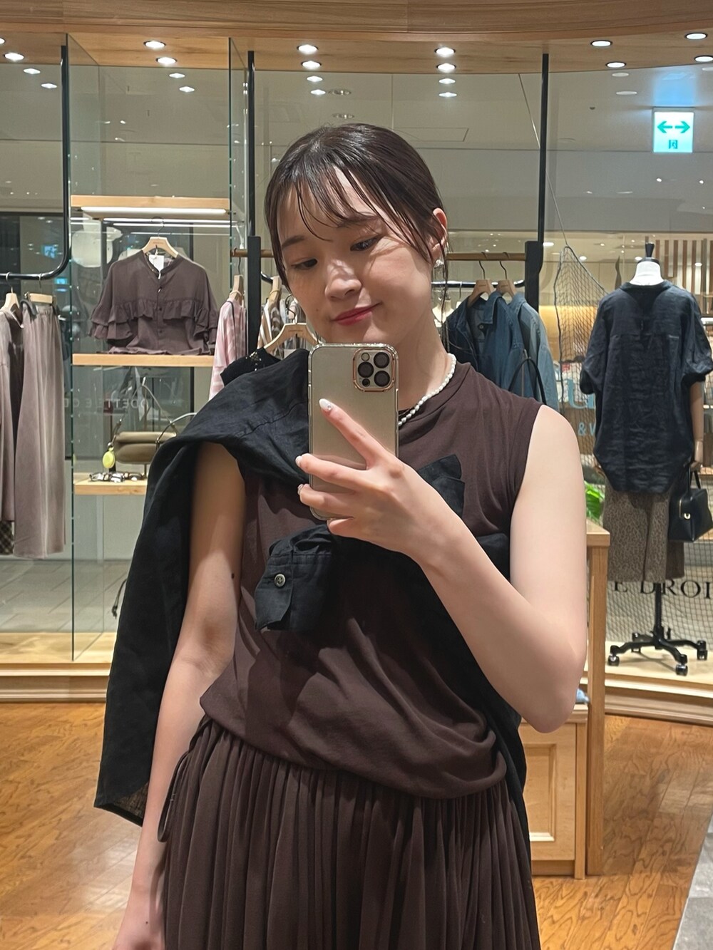 ブラウン系のワンピース、ブラック系のシャツ/ブラウス、ベージュ系のサンダルを着用したレディースの夏コーディネートの2枚目の写真