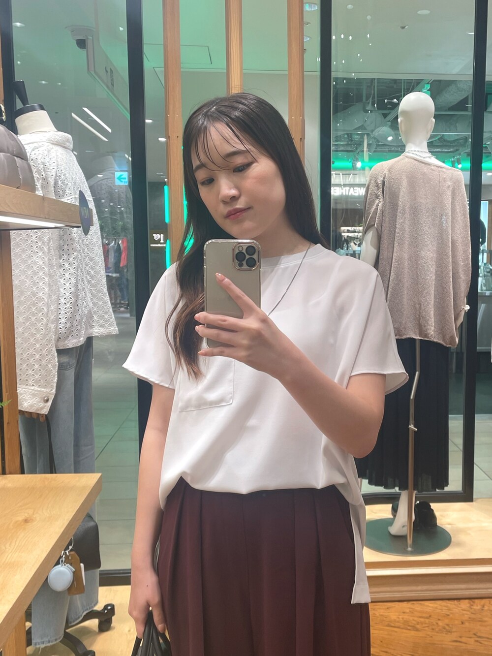 レッド系のスラックス、ブラック系のボストンバッグ、ブラック系のパンプスを着用したレディースの夏コーディネートの2枚目の写真