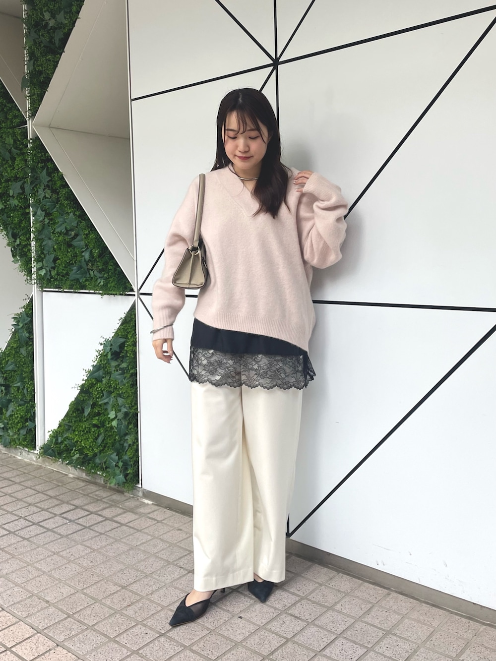 ベージュ系のハンドバッグ、ブラック系のパンプス、ピンク系のニット/セーターを着用したレディースの秋コーディネートの4枚目の写真