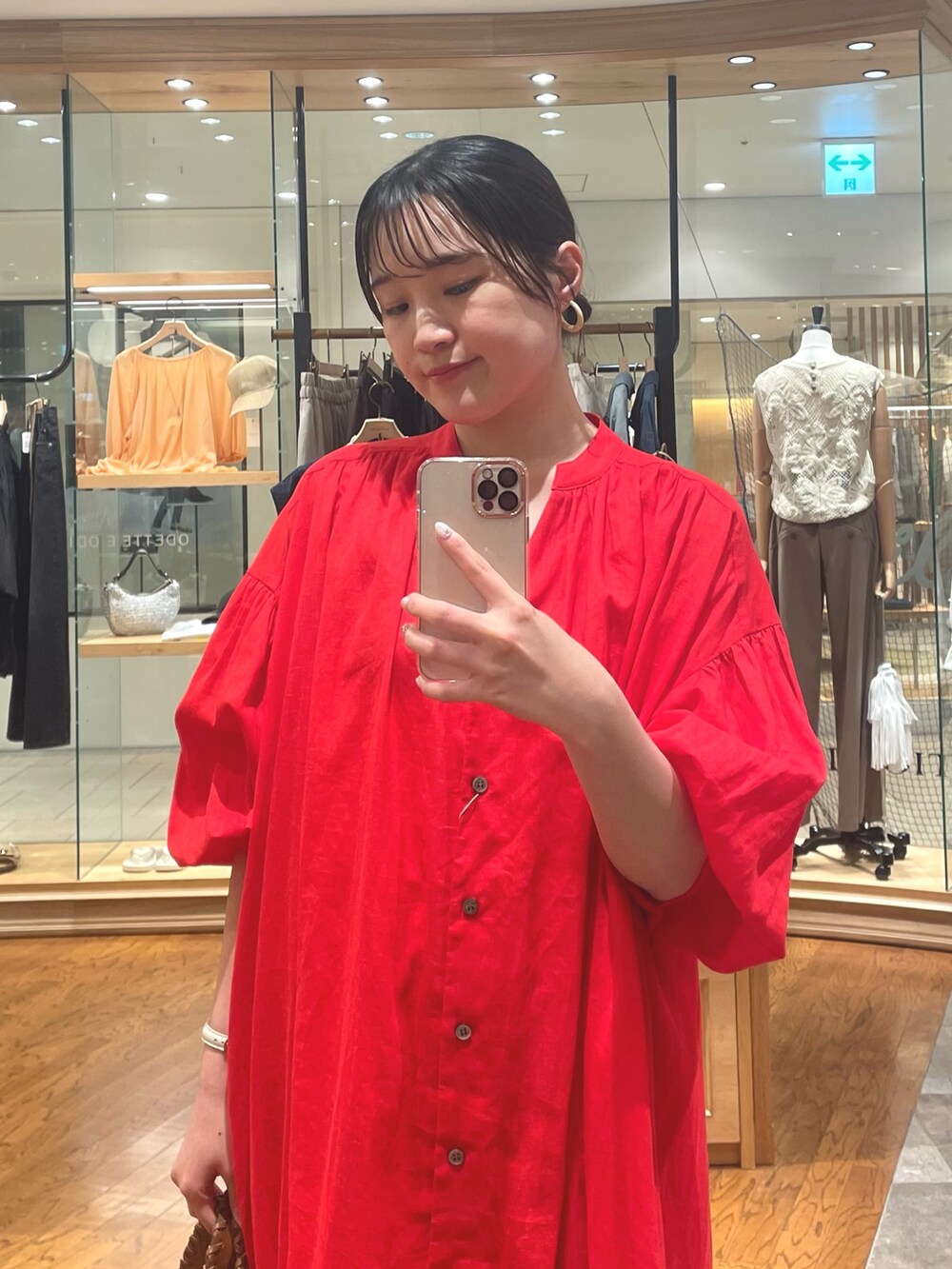 レッド系のワンピース、ベージュ系のサンダル、ベージュ系のイヤリングを着用したレディースの夏コーディネートの2枚目の写真