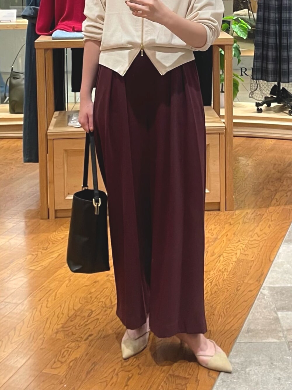 ホワイト系のカーディガン/ボレロ、レッド系のスラックス、ベージュ系のパンプスを着用したレディースの秋コーディネートの3枚目の写真