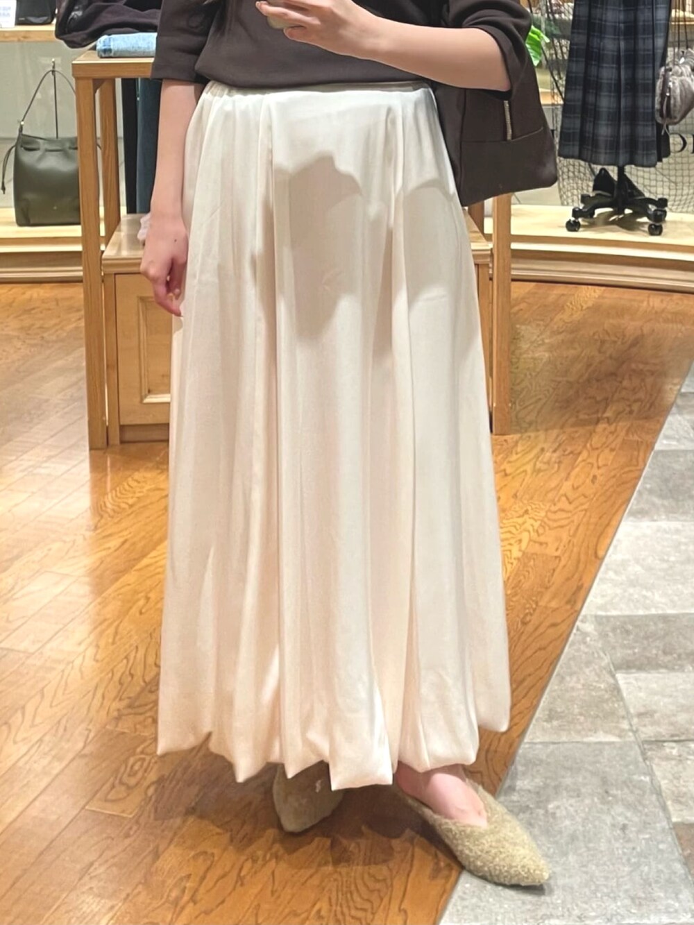 ホワイト系のスカート、ベージュ系のその他シューズ、ブラウン系のボストンバッグを着用したレディースの夏コーディネートの3枚目の写真