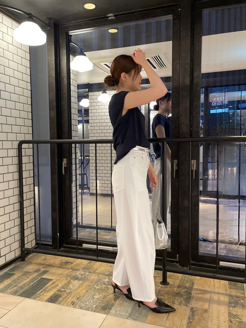 ブルー系のニット/セーター、ホワイト系のその他パンツ、シルバー系のショルダーバッグを着用したレディースの夏コーディネートの2枚目の写真