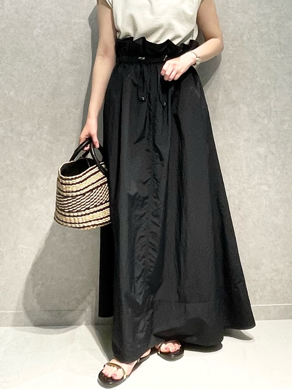 ベージュ系のTシャツ/カットソー、ブラック系のスカート、ブラック系のショルダーバッグを着用したレディースの春コーディネートの2枚目の写真