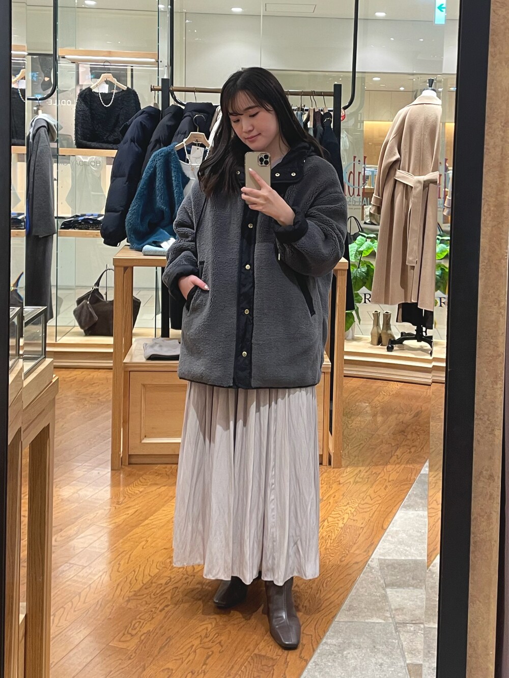 グレー系のその他アウター、ベージュ系のスカート、ブラウン系のブーツを着用したレディースの冬コーディネートの3枚目の写真