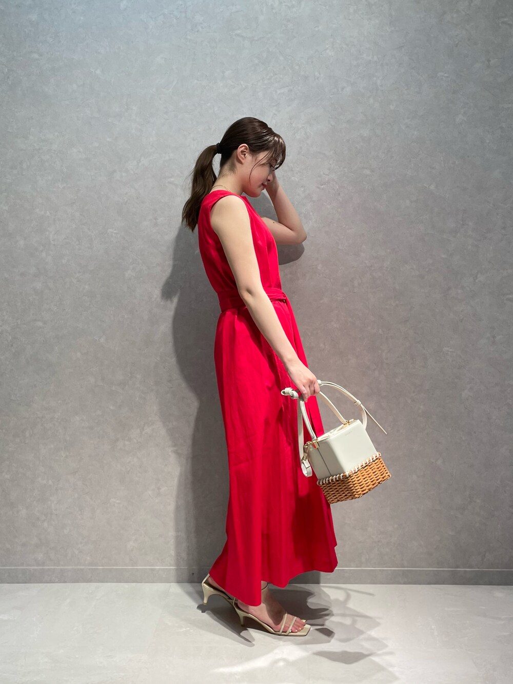 レッド系のワンピース、ホワイト系のショルダーバッグ、ベージュ系のサンダルを着用したレディースの夏コーディネートの2枚目の写真