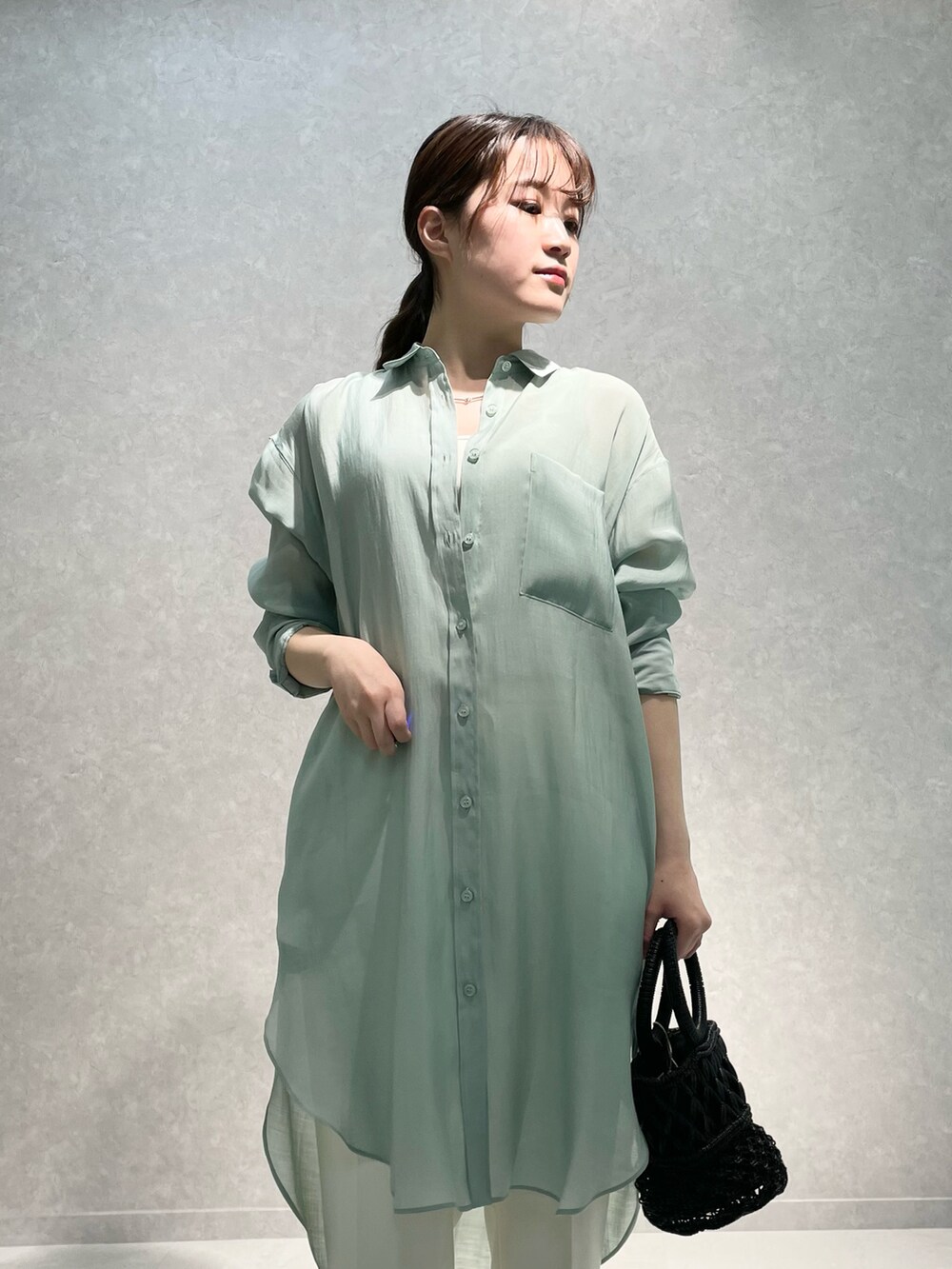 ゴールド系のサンダル、グリーン系のトップス、ホワイト系のその他パンツを着用したレディースの春コーディネートの3枚目の写真