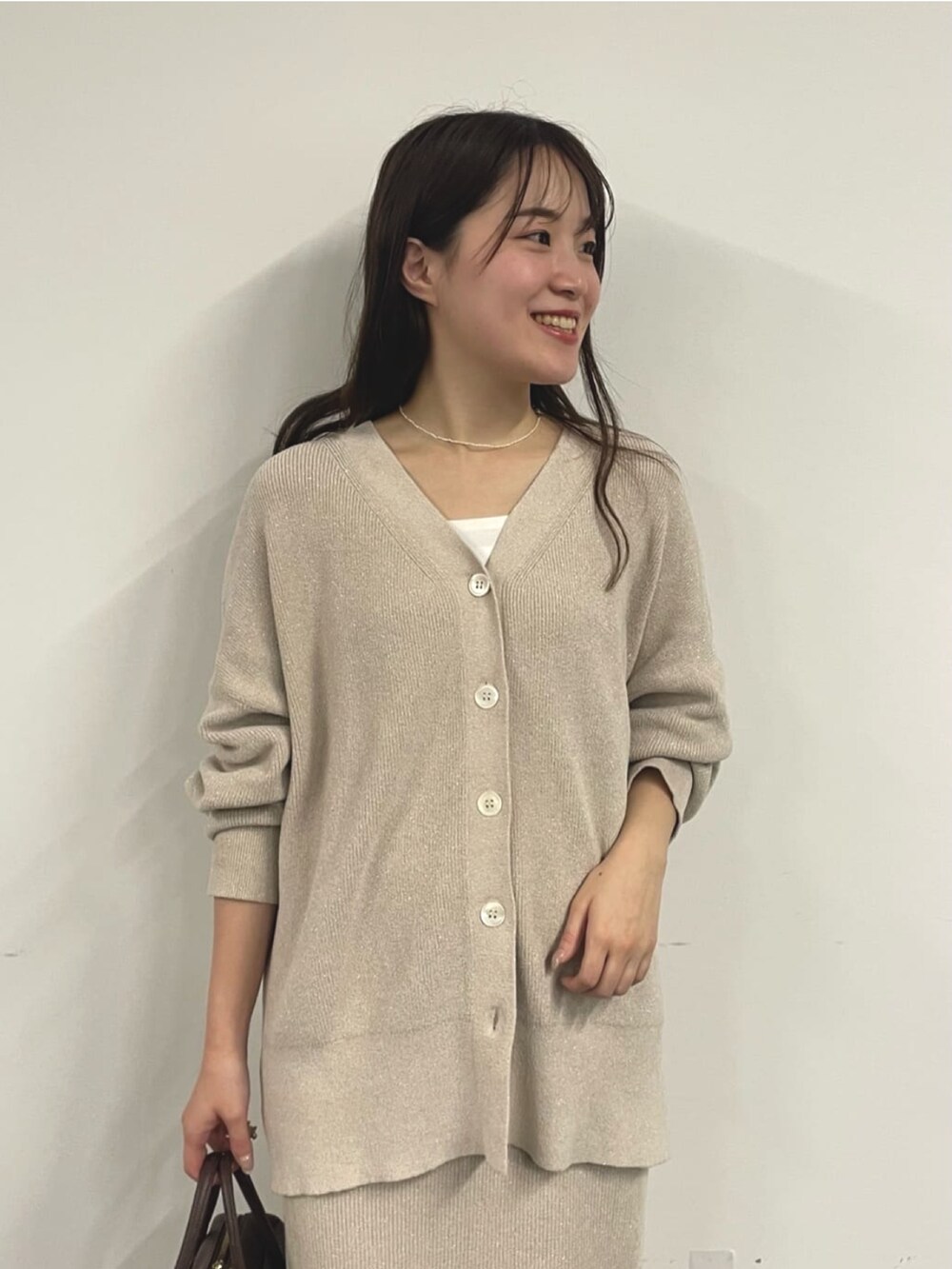 ホワイト系のニット/セーター、ブラック系のブーツ、ホワイト系のスカートを着用したレディースの秋コーディネートの2枚目の写真