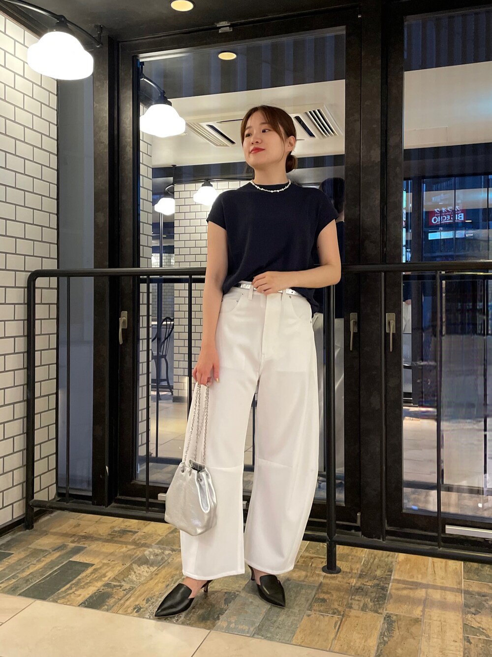 ブルー系のニット/セーター、ホワイト系のその他パンツ、シルバー系のショルダーバッグを着用したレディースの夏コーディネートの4枚目の写真