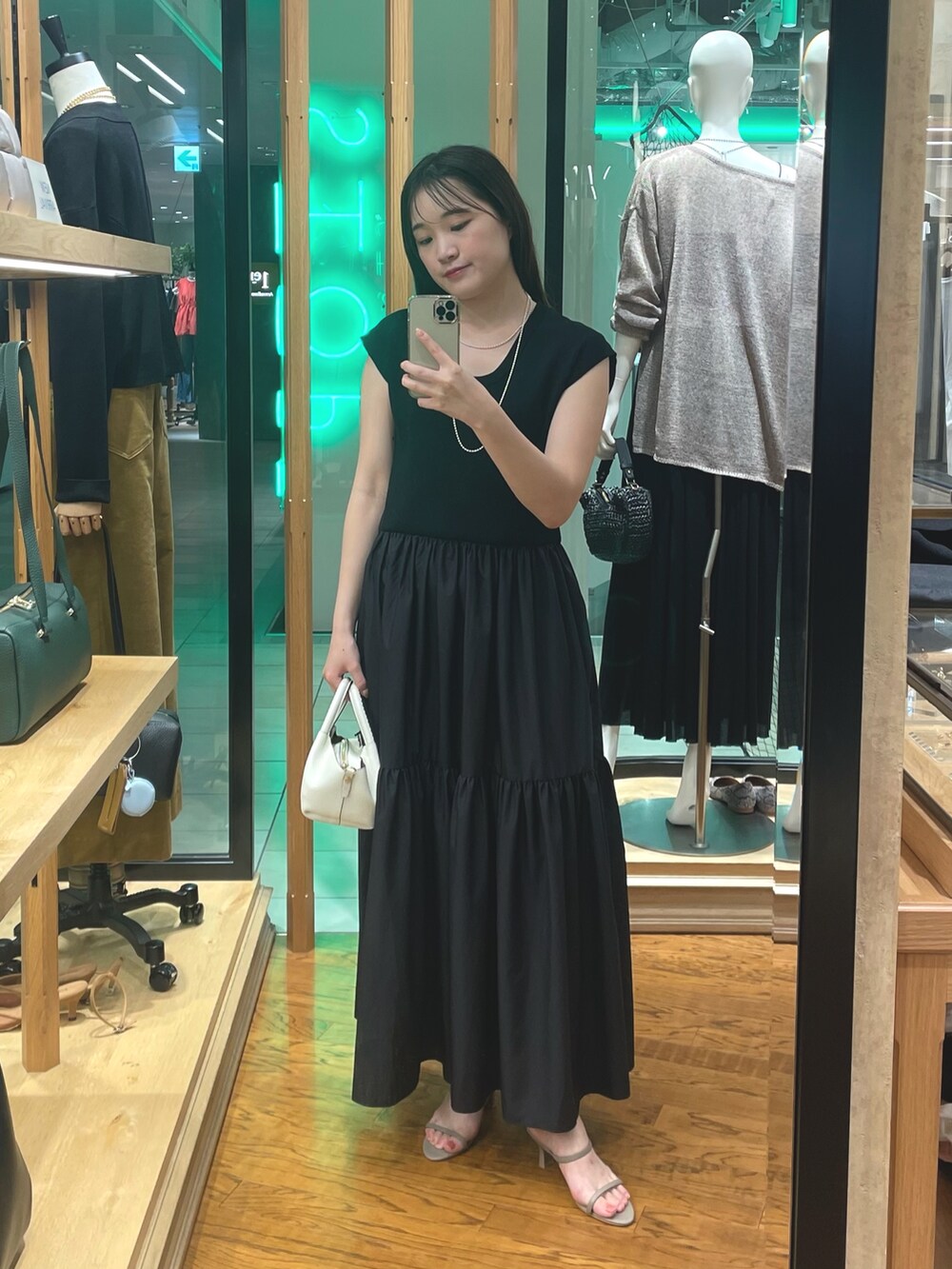 ブラウン系のワンピース、ブラック系のテーラードジャケット、シルバー系のネックレスを着用したレディースの夏コーディネートの3枚目の写真